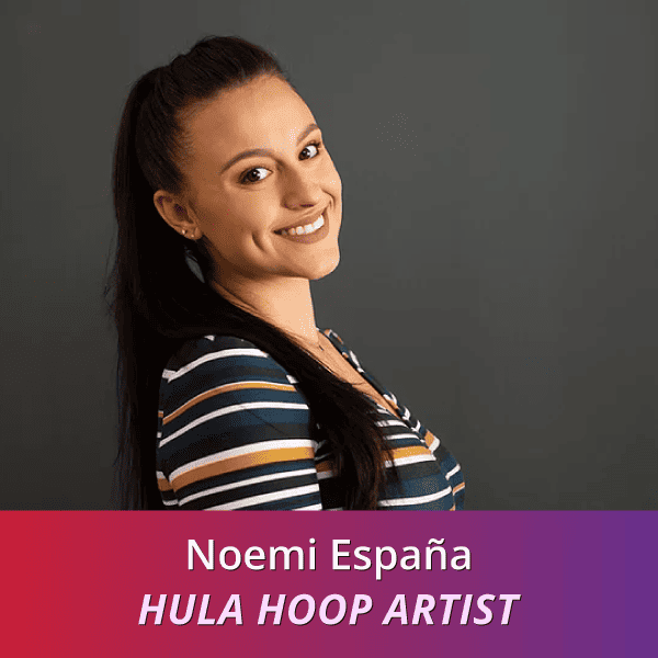 Noemi España: Hula Hoop Artist, a Hispanic woman with long dark hair wearing a gray and mustard striped shirt; she is standing to the side, with her shoulder facing the camera.