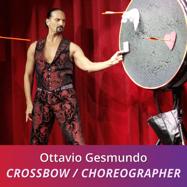 Octavio Gesmundo: Crossbow/Choreographer, a tan man wearing a red and black paisley vest and pantsuit holding a tiny card up next to a target; an orange arrow is visible to the left of him.
