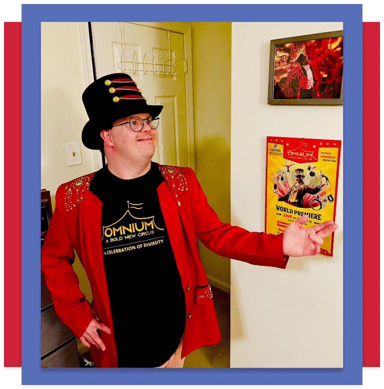 Ringmaster Eric gestures in a red jacket against an Omnium poster